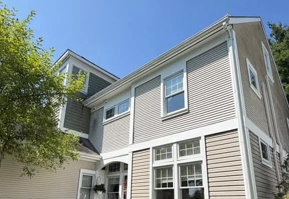 Taupe exterior siding with white window trim