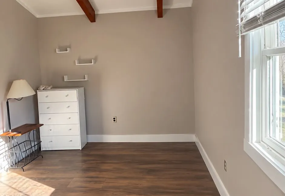 Neutral painted walls, white trim and wood beams in a sunlit room
