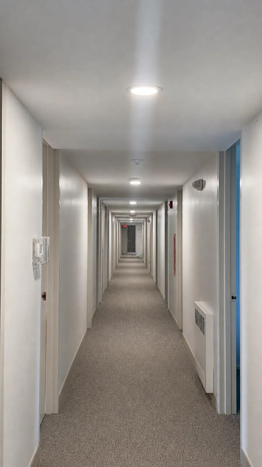 Clean corridor with white walls and recessed lighting