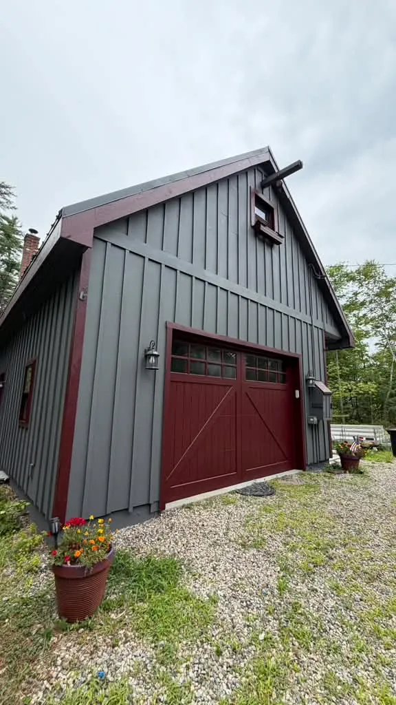 Gray board-and-batten siding and a burgundy garage door