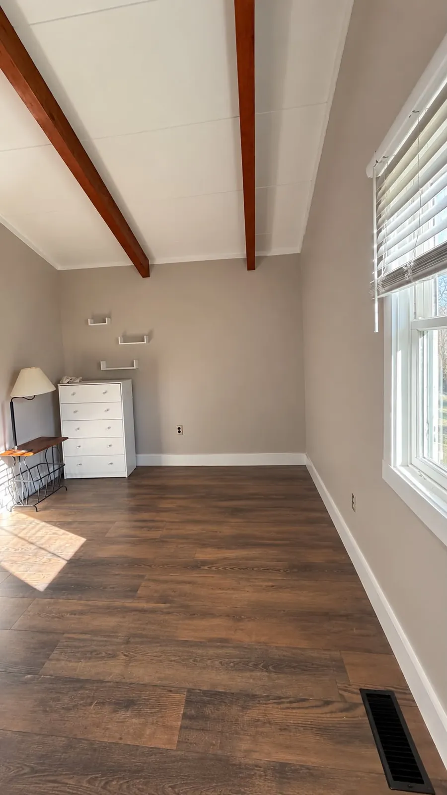 Neutral painted room with white trim and exposed wood beams